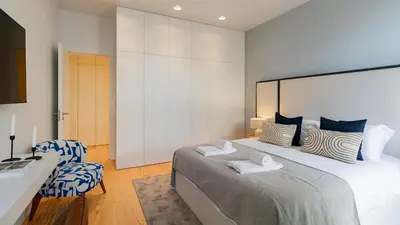 a bedroom with a large bed and a desk and chairs at Almada 551 by LovelyStay in Porto