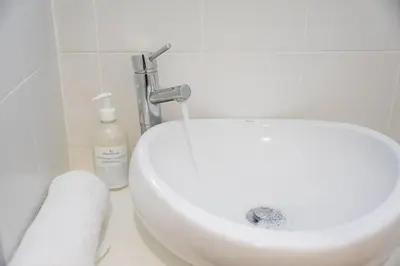 a bathroom with a white sink and a bottle of soap at GuestReady - Breyner Stonewall Haven in Porto