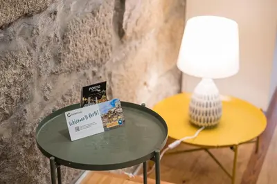 a table with a lamp and a table with a book on it at GuestReady - Breyner Stonewall Haven in Porto