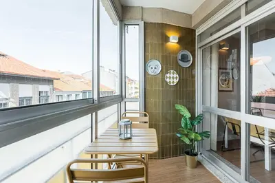 a balcony with a table and chairs and a window at GuestReady - A warm city refuge in Cedofeita in Porto