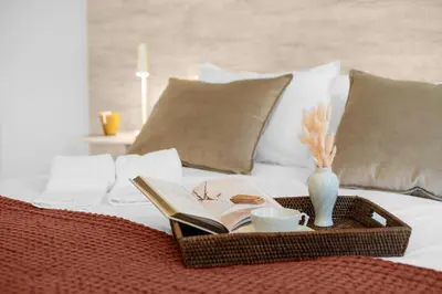 a tray with a book and a cup on a bed at Sittium in Porto