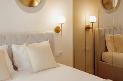 a bedroom with a bed with white pillows and a mirror at Clerigos Boutique Apartments by Hosty in Porto