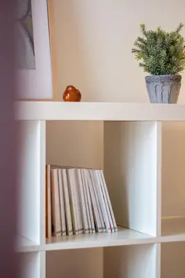 a white shelf with books and a potted plant at Porto 61 - Bright 2BR w/ Balcony by LovelyStay in Porto
