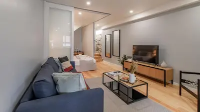 a living room with a blue couch and a tv at Belomonte 103 by LovelyStay in Porto