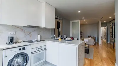 a kitchen with a washing machine and a living room at Belomonte 103 by LovelyStay in Porto