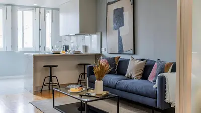 a living room with a blue couch and a kitchen at Belomonte 103 by LovelyStay in Porto