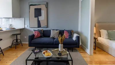 a living room with a blue couch and a table at Belomonte 103 by LovelyStay in Porto