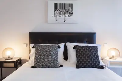 a bedroom with a bed with black and white pillows at Urban Views - ML 2Bed Apart Inspired by Casa da Música in Porto