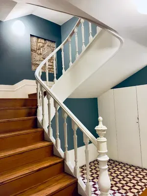 a staircase in a house with blue walls and wooden floors at Stylish Flat City Center in Porto