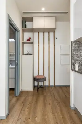 a room with white walls and wooden floors and a chair at Alma Bonfim Apartments in Porto