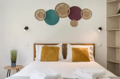 a bedroom with a bed with towels on it at Alma Bonfim Apartments in Porto