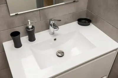 a white bathroom sink with two black cups on it at Alma Bonfim Apartments in Porto