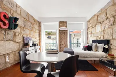 a room with a bed and a table and chairs at Oporto Chic & Cozy Studio Apartments in Porto
