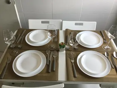 a table with white plates and wine glasses on it at Vicky Porto in Porto