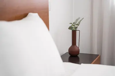a vase sitting on a table next to a bed at GuestReady - Casegas residence in Marquês in Porto