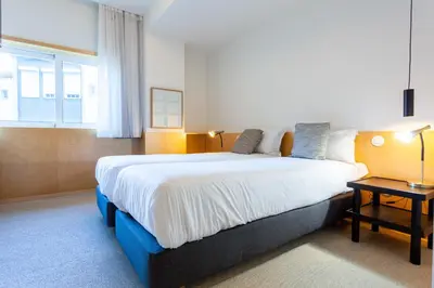 a bedroom with a large bed and a window at Oporto City View - Guest House Suites in Porto