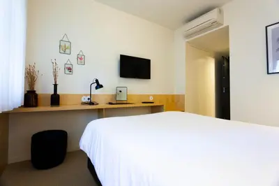 a bedroom with a white bed and a television at Oporto City View - Guest House Suites in Porto