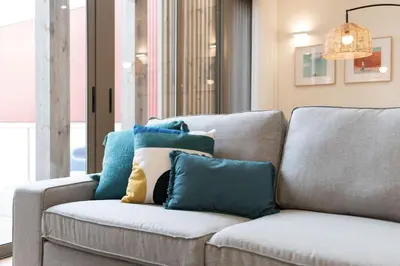 a couch with pillows on it in a living room at AgapeStay Family House in Porto