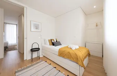 a white bedroom with a bed with a yellow blanket on it at AgapeStay Family House in Porto