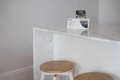 a counter with a wooden stool and a table at GuestReady - The perfect haven near St. Catarina in Porto