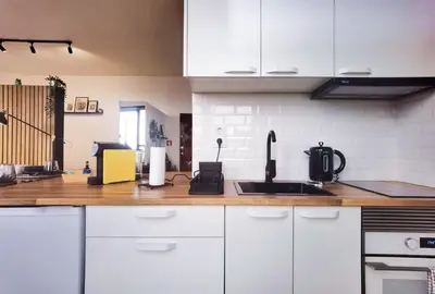 a kitchen with white cabinets and a sink at Ninho 424 in Porto