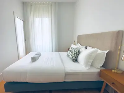 a bedroom with a large bed with white sheets and pillows at Vibrant Host -Bonfim in Porto
