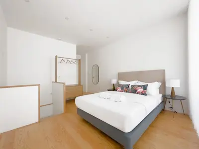 a white bedroom with a large bed and a window at Vibrant Host -Bonfim in Porto