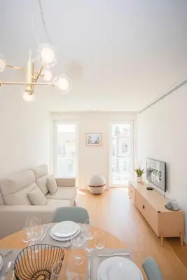 a white living room with a table and a couch at Liiiving in Porto - Crystal Palace Apartment in Porto