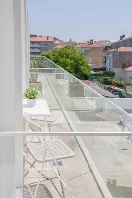 a balcony with a table and chairs on a building at Liiiving in Porto - Crystal Palace Apartment in Porto