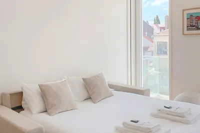 a white bed in a room with a large window at Liiiving in Porto - Crystal Palace Apartment in Porto