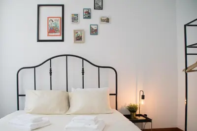 a bed with two white pillows and pictures on the wall at Goodgarden Downtown Apartment in Porto