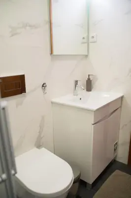 a white bathroom with a toilet and a sink at Goodgarden Downtown Apartment in Porto