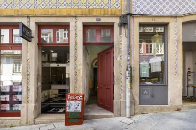 a store front with red doors on a street at WHome Central 1-Bed w/ Top View perfect to Explore Porto in Porto