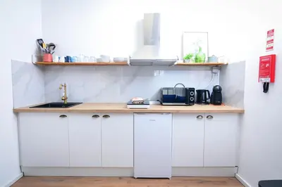 a kitchen with white cabinets and a sink at Travel & Live Fernão Magalhães in Porto
