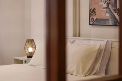 a bedroom with a bed with a pillow and a lamp at Travel & Live Fernão Magalhães in Porto