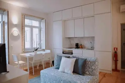 a living room with a couch and a kitchen with a table at Porto Apartments in Porto