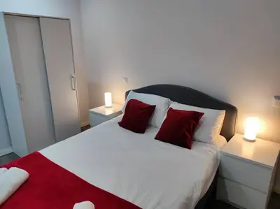 a bedroom with a large bed with two red pillows at Torre dos Clérigos Apartment in Porto