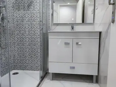 a white bathroom with a sink and a shower at Torre dos Clérigos Apartment in Porto