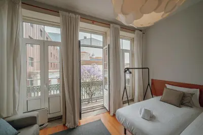 a bedroom with a bed and a large window at Moinho de Vento Studios in Porto
