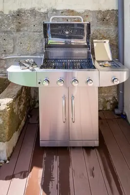 a barbecue grill sitting on top of a wooden floor at OPO Vale Formoso II Garden & BBQ in Porto