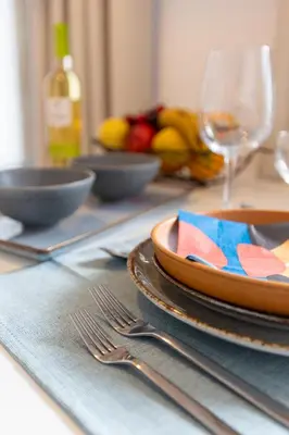 a table with plates and forks and glasses on it at OPO Vale Formoso II Garden & BBQ in Porto