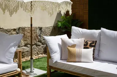 a group of pillows sitting on a chair with a umbrella at OPO Vale Formoso II Garden & BBQ in Porto