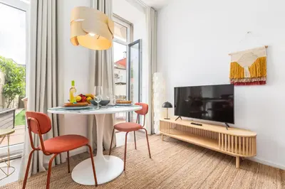 a living room with a table and a tv at OPO Vale Formoso II Garden & BBQ in Porto