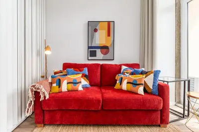 a red couch with colorful pillows in a living room at OPO Vale Formoso II Garden & BBQ in Porto