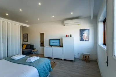 a bedroom with a bed and a living room at Plano C 2 Oporto Downtown in Porto