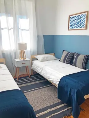 two beds in a room with blue and white at Cozy 3 room apartment near House of Music in Porto