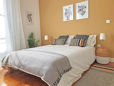 a bedroom with a large bed with pillows on it at Cozy 3 room apartment near House of Music in Porto