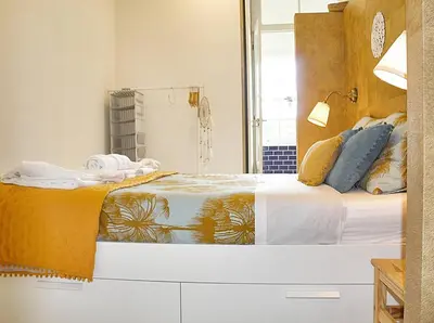 a bedroom with a bed with white sheets and blue pillows at Benskins Loft Oporto Downtown in Porto