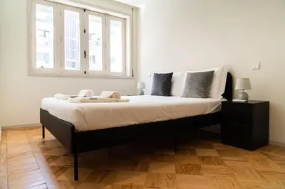 a bedroom with a large bed with a window at Charmant appartement climatisé avec balcons in Porto