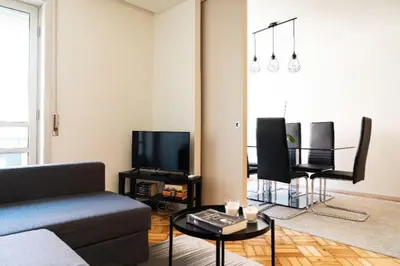 a living room with a couch and a table at Charmant appartement climatisé avec balcons in Porto